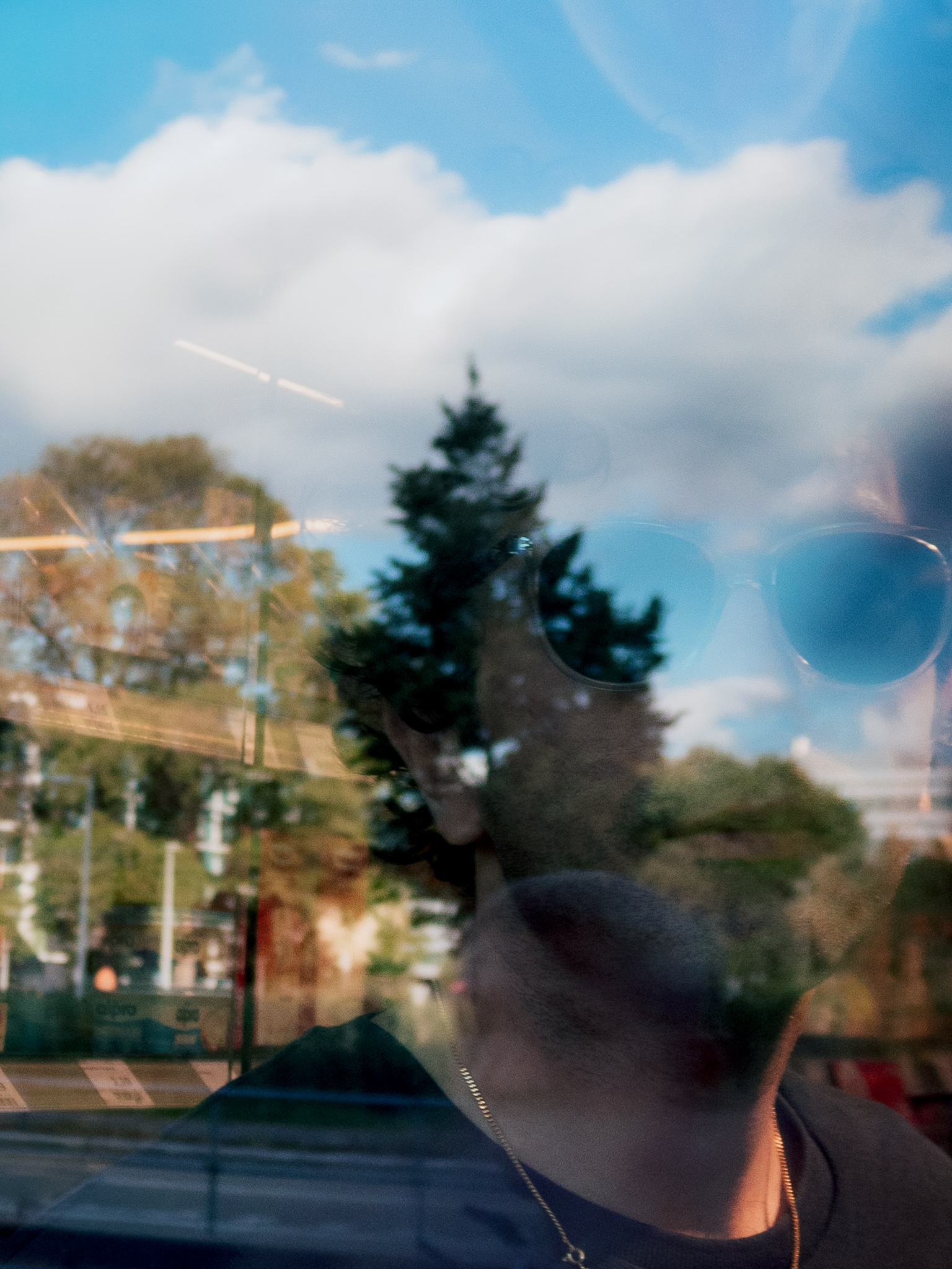 Portrait reflected in a window beneath a blue sky